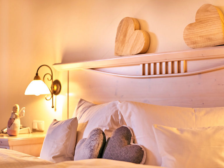 Schön dekoriertes Bett mit Herzmotiven im Hotel St. Gunther im Bayerischen Wald